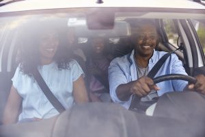 Family driving in car with teen children