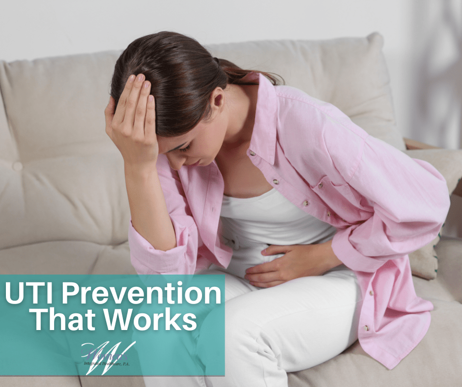 A woman holding her midsection in discomfort with her hand on her head.