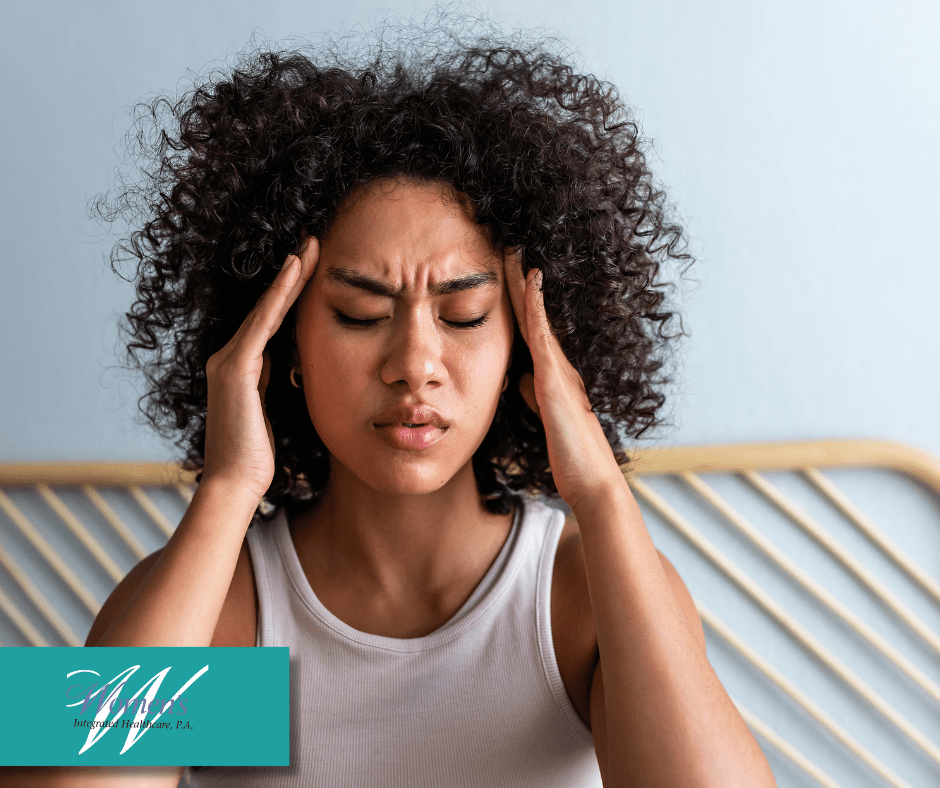 An African-American woman rubbing her temples due to a headache.